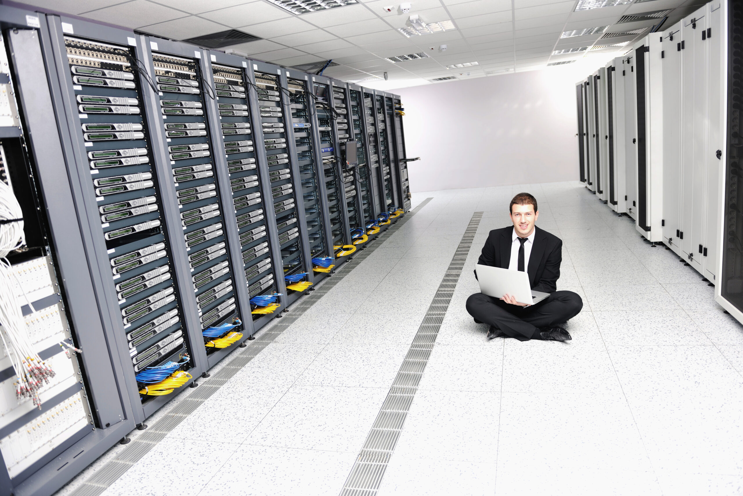 young it  engeneer business man with thin modern aluminium laptop in network server room