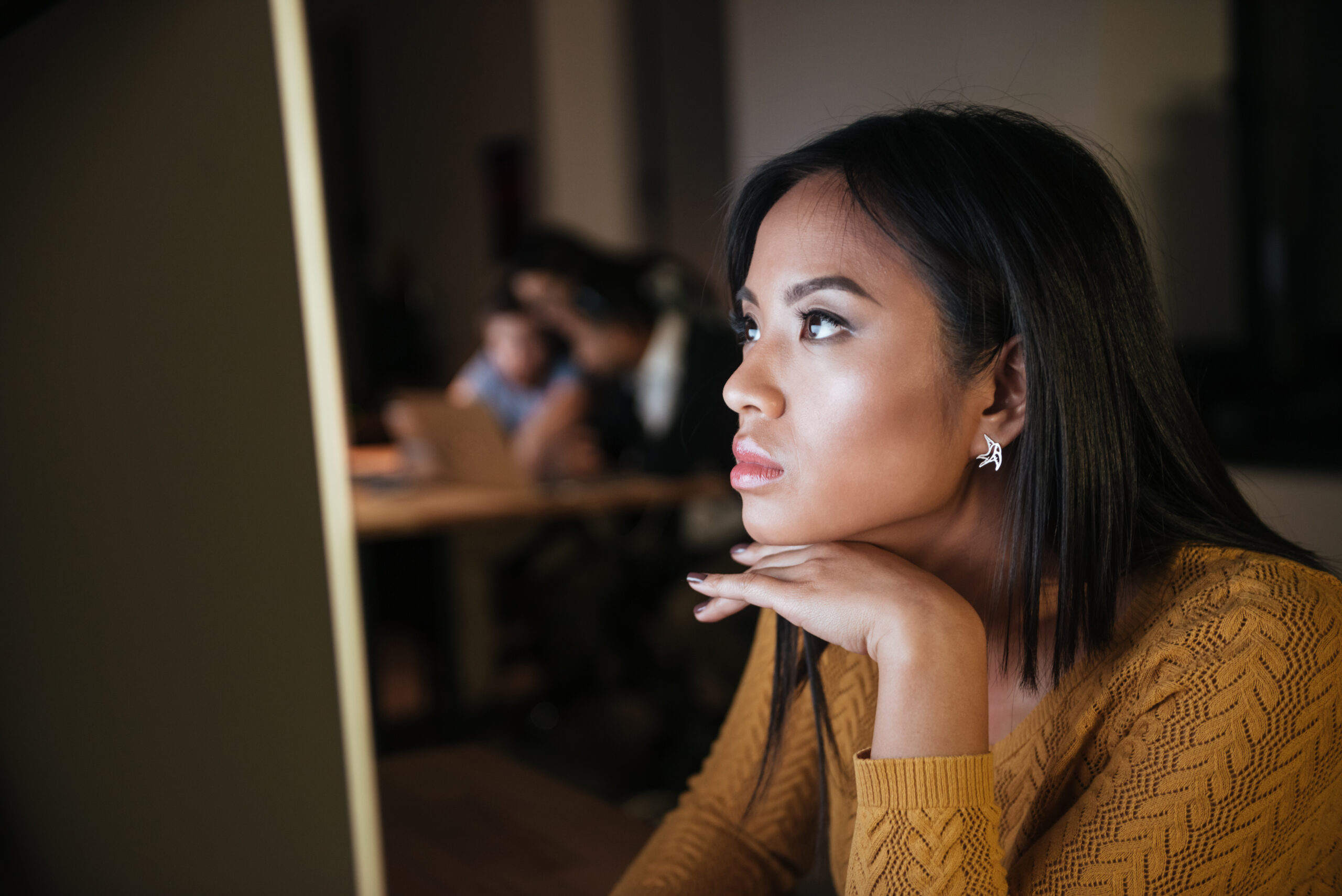 Businesswoman working late at night in office with computer. Looking at computer.